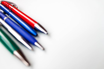 row selection of assorted multi colored ballpoint pens of different colors on light blue background. Back to school creativity concept. Selective focus, text copy space.