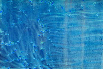 Blue metal background with scratches in the form of strips and waves