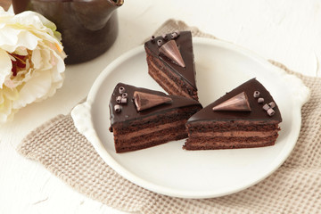 Chocolate cake slice with curl on white background