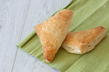 Apple turnover on a green tea towel with a grey wood background
