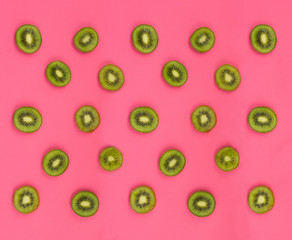 Colorful fruit pattern of fresh kiwi slices on pink background. From top view