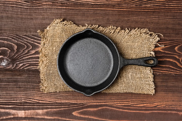 Empty mini cast-iron skillets on wooden table, view from above