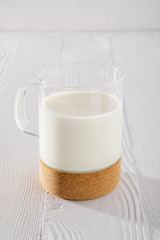 Glass of milk on white wooden kitchen table