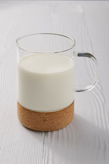 Glass of milk on white wooden kitchen table