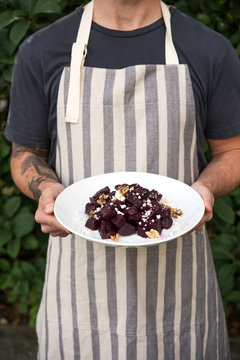Man with apron holding beets