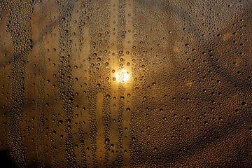 sunset through misted glass with drops and drips background rain