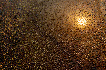 sunset through misted glass with drops and drips background rain