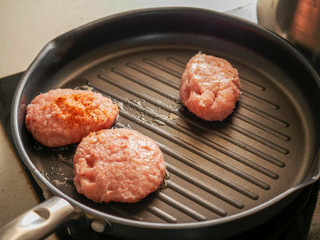 Cooking process, Turkey burgers on a frying pan.