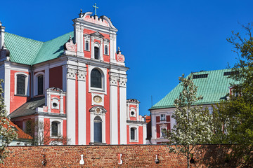 Baroque Catholic Church behind medieval defensive wall in Poznan.