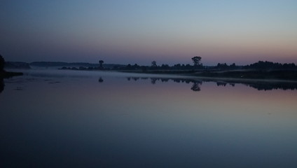 Summer landscape, pond and forest on the horizon.