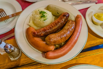 German mixed sausages for beer with mashed potatoes, greens, stewed cabbage and seasonings.