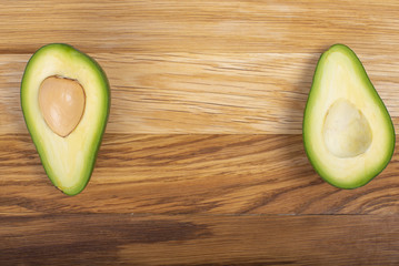 Avocado on a wooden board cut in half
