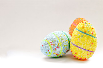 Three colorful handmade Easter eggs isolated on white background.