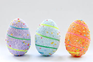 Three colorful handmade Easter eggs, on a white background. Spring Easter holiday.