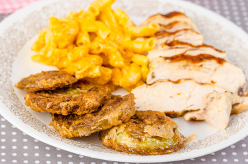 Selective Focus on Fried Green Tomatoes on Plate with Pork Tenderloin and Mac and Cheese.
