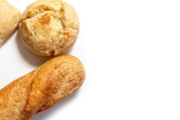 Assortment of wheat baked bread with golden crust on white background with copy space