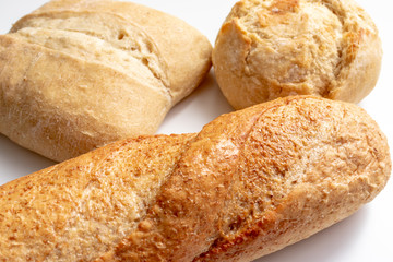 Assortment, different kind of wheat baked bread with golden crust on the table