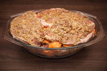 meat marinated in spices ready for baking in the oven or on the grill with attachments. served on a party with friends in the garden or at home