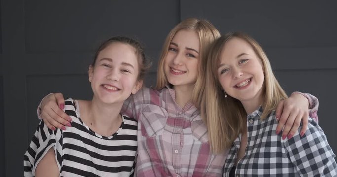 Happy teenage girls with arm around