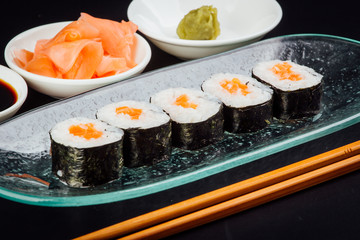 Salmon maki sushi rolls on a black background, japanese food