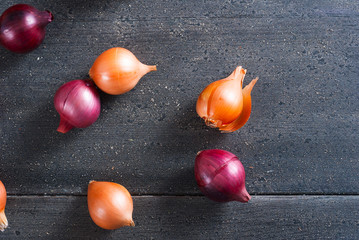 spanish and red onions on black wooden table