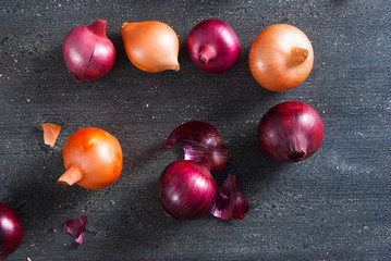 spanish and red onions on black wooden table