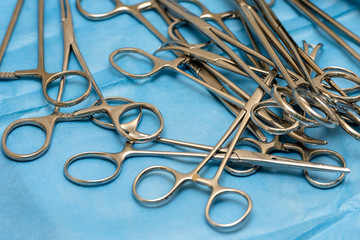 A lot of medical equipment scissors on blue background.