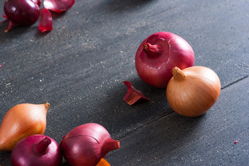 spanish and red onions on black wooden table