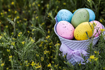 Bright Easter eggs in a purple bucket with copy space on the left