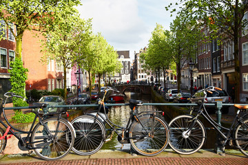 Obraz premium Amsterdam street canal with typical dutch houses and bikes. Holland, Netherlands