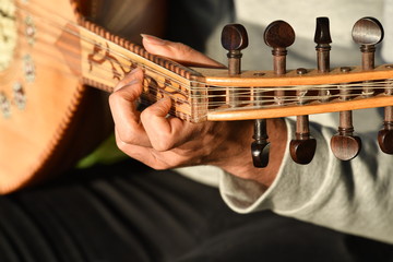 An arabic man playing the oud-guitar.