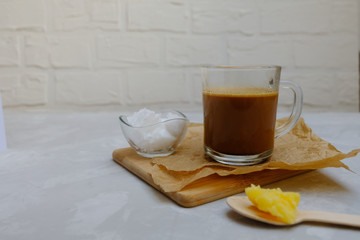 Bulletproof coffee blended with ghee oil and coconut oil on neutral grey background. Image with copy space.