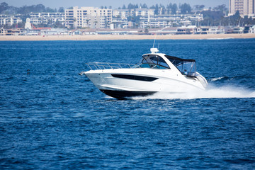 Fototapeta premium Speedboat cuts through the water of the bay