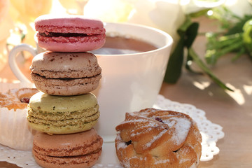 Fresh macaroons with tea on a light background. Extremely shallow depth of field with selective focus in the foreground.