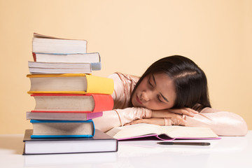 Exhausted Young Asian woman sleep with books on table.