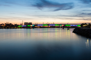 Multicolored lighted bridge over bay at sunset long exposure