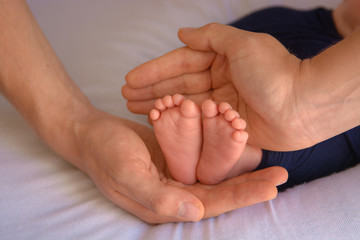 newborn baby feet and hands of parents