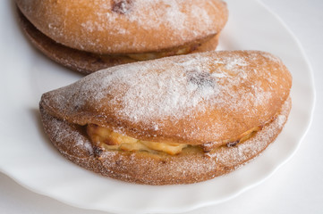 Homemade buns stuffed with cottage cheese lie on a white plate. Close up. Selective focus