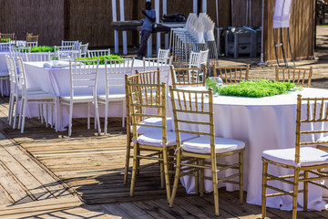 wedding event white environment patio restaurant exterior with table covered tablecloth and wooden chairs, nobody 