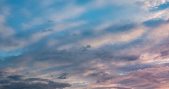 Time lapse clip of gray fluffy curly rolling clouds in windy weather in the evening