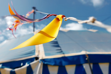 Close-up macro of colorful pennants in a blue circus tent