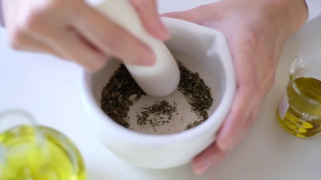 the scientist  doctor is making natural  herb medicine or cosmetic in the laboratory. grind herbal  in the mortar . on table with  organic essential oil . skincare health product industry .closeup