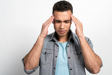 Closeup portrait of a man holding his head, headache or badly upset, drooping face down