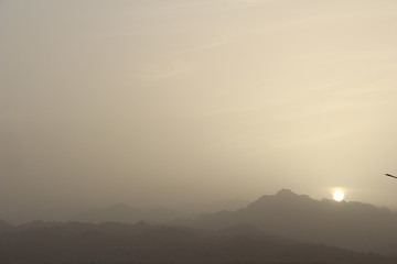sunset in the misty haze on a background of mountains