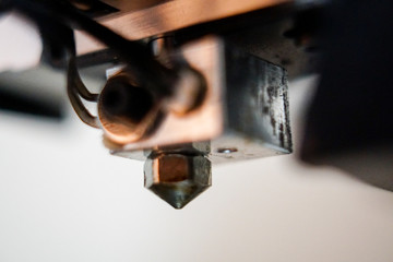 close up of 3d printer nozzle, fan, stepper motor and wires