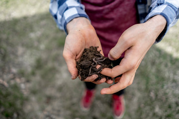 young man hold bunch of soil with earth worms b