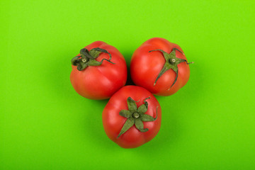 red tomatoes on green background