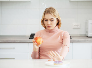 Diet. The concept of healthy and unhealthy nutrition. The model plus size makes a choice in favor...