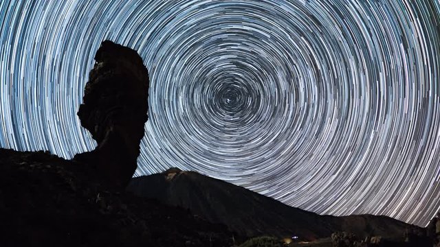 Time lapse of star trails moving over Teide volcano and Los Roques de Garcia rocks, Teide National Park, Tenerife, Canary islands, Spain.