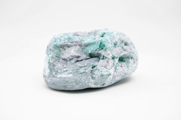 Natural raw mineral emerald nestled in gray bedrock close-up isolated on white background